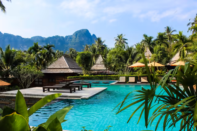 Resort pool at dusk overlooking the Chao Phraya