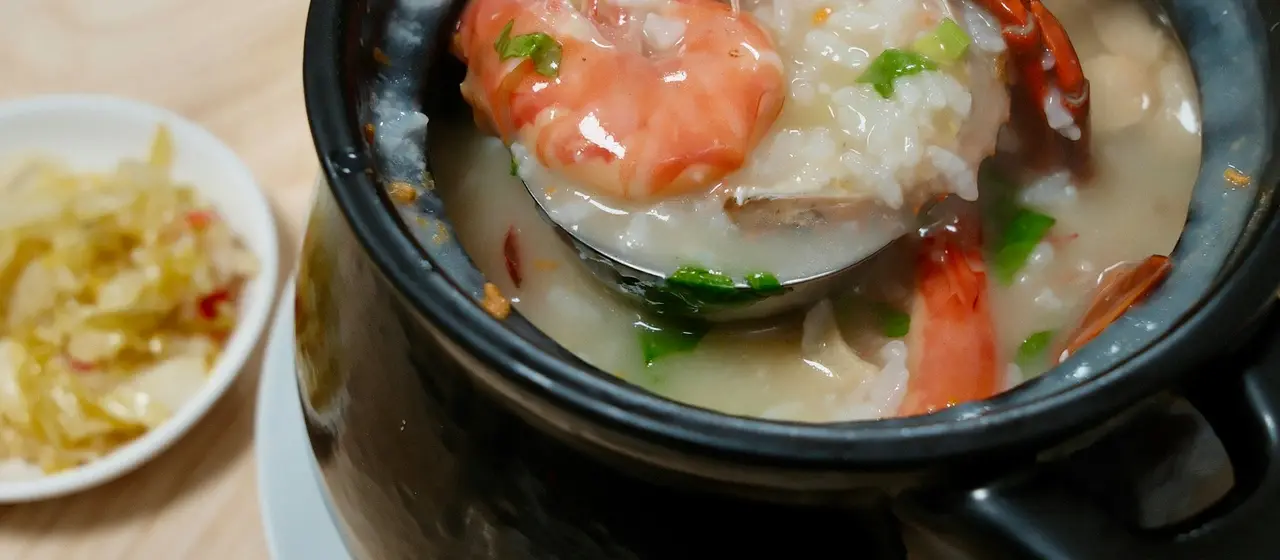 Thai rice soup and breakfast dishes on a wooden table