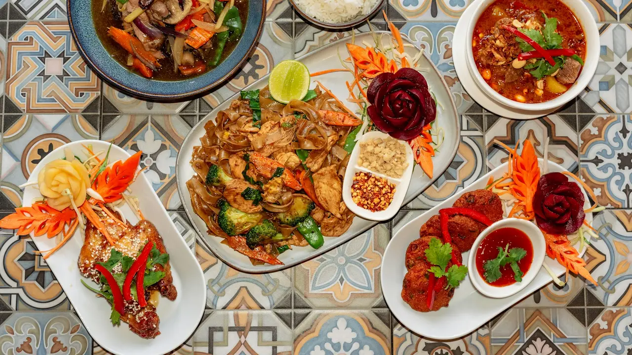 Thai dishes served on a dark table, close crop