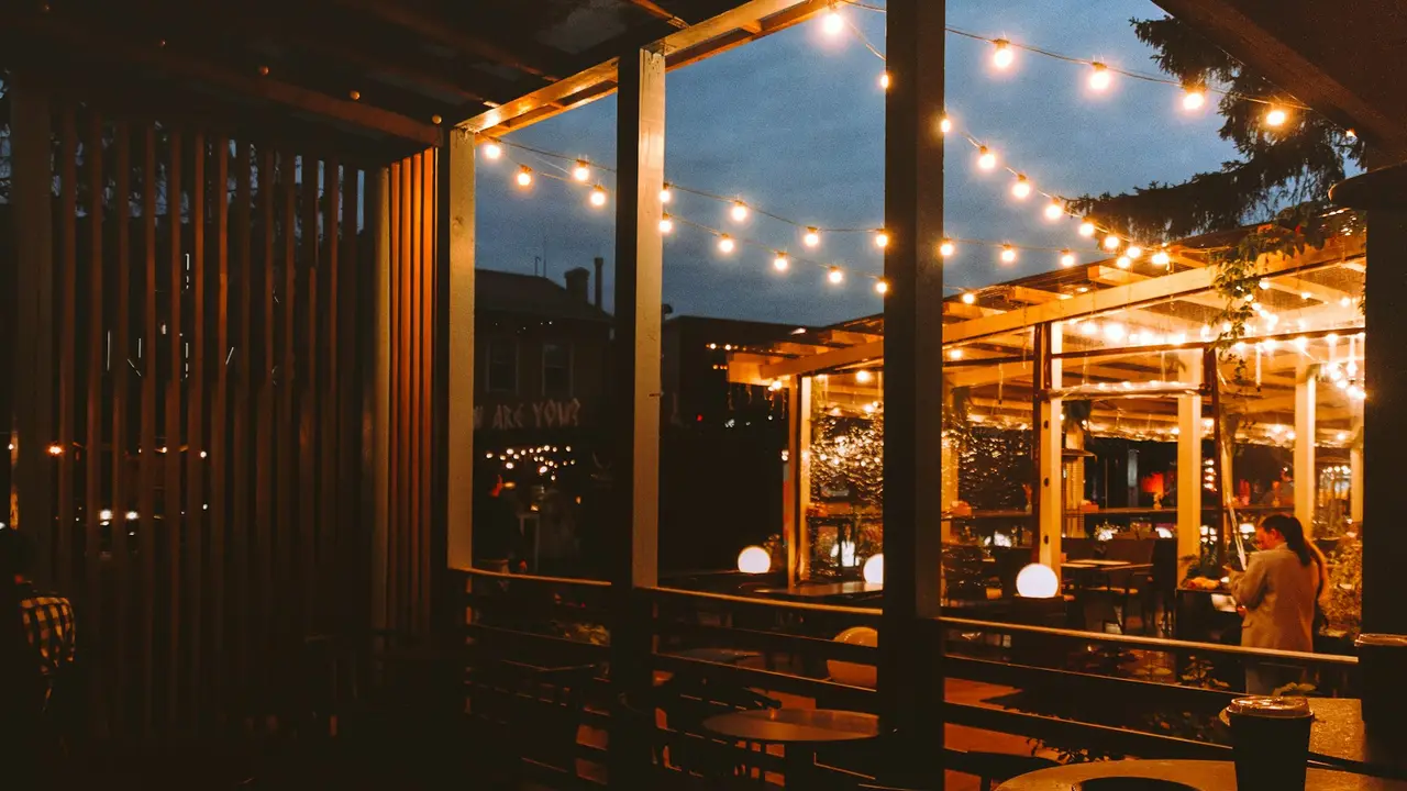 A table set for dinner in the riverside pavilion under string lights