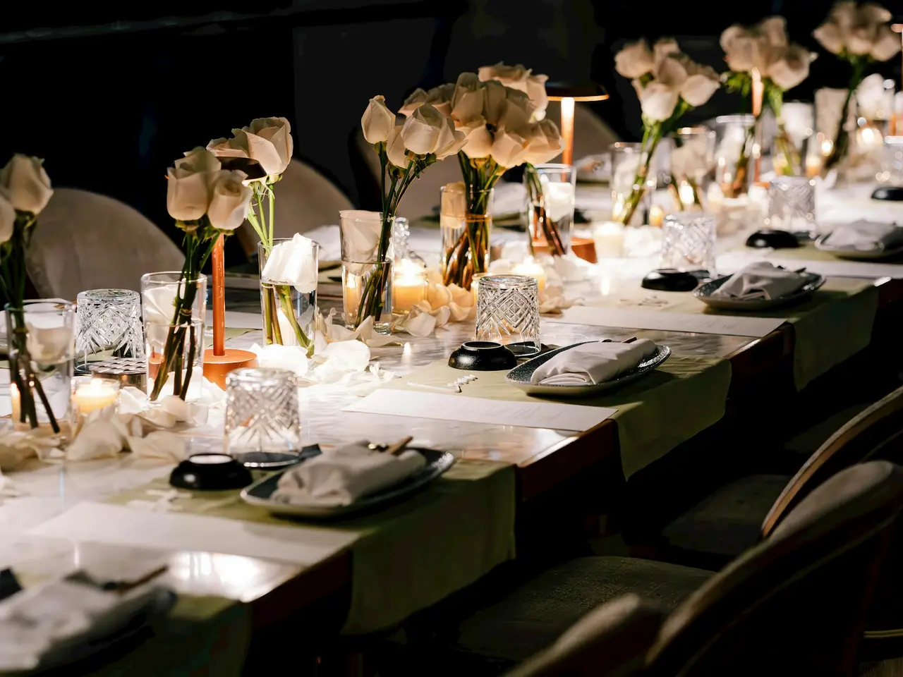 A long table laid for dinner under string lights